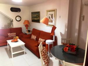 un salon avec un canapé et une table dans l'établissement Precioso dúplex con piscina, en 1ª linea de playa, à Puerto de Mazarrón