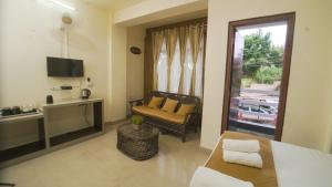 a room with a bed and a couch and a window at Ha Sharing in Shillong