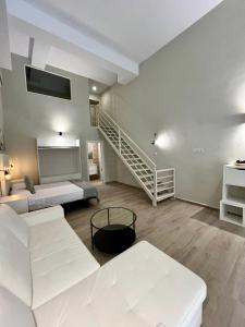 a living room with white furniture and a staircase at Ribera Suites GP in Córdoba