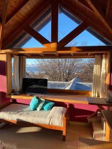 a bed in a room with a large window at Posada Del Fin Del Mundo in Ushuaia