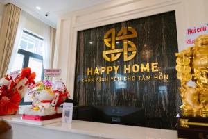 a happy home sign on a wall with a table with cakes at Happy Home Dak Lak in Buôn Mhang