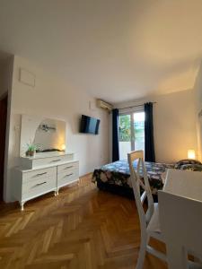 a bedroom with a bed and a dresser and a mirror at Alina's apartment in Bečići