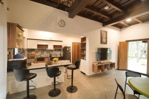 a kitchen with a table and stools in a room at Mogra Nilayam in Payyannūr