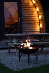 a fire pit in front of a picnic table at night at Grassington Farm by Wigwam Holidays in Helston