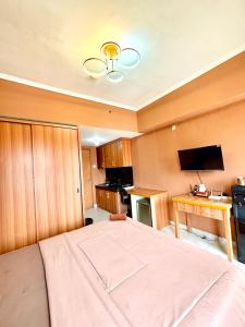 a bedroom with a large bed and a desk at Room Transit 3jam Apartemen Margonda Residence 2 By Younz Apartemen in Pondokcina +15 photos