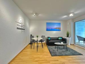 a living room with a couch and two tables at Auszeit Apartment HAPPY in Friedrichshafen +8 photos
