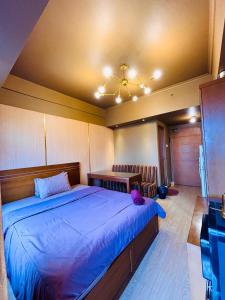 a bedroom with a large bed with a blue comforter at Room Transit 3jam Apartemen Margonda Residence 2 By Younz Apartemen in Pondokcina