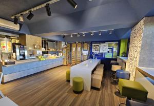 Un restaurante con un mostrador, una mesa y sillas. en B&B HOTEL Thionville Yutz A31, en Basse-Yutz