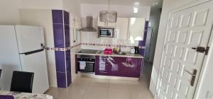 a kitchen with purple and white cabinets and a refrigerator at Sunset Las Galletas in Las Galletas +19 photos