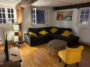 a living room with a black couch and a yellow chair at Trop chouette au centre de Dijon in Dijon