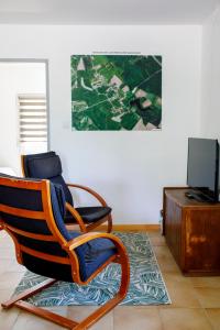 a living room with a rocking chair and a television at le petit gite de Marinette in Villers-Robert