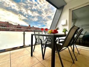 a table with a bowl of fruit on a balcony at Auszeit Apartment LAKELIFE in Friedrichshafen