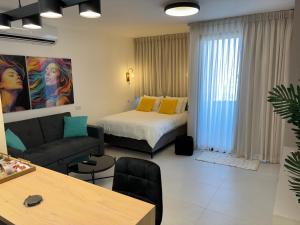 a living room with a bed and a couch at Boutique Suite Tal in Eilat