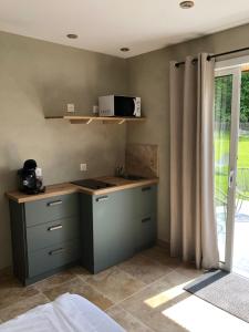 a kitchen with a counter with a microwave on it at La maison Buis chambres d hotes in Quiestède