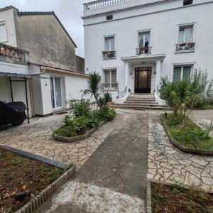 a white house with a courtyard in front of it at Le patio Aristide in Champigny-sur-Marne