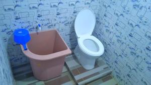a bathroom with a toilet and a trash can at HOTEL ANANDA in Meureudu