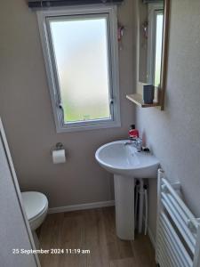 a bathroom with a sink and a window at Lewis Sands PC114 in Lossiemouth +11 photos