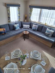 a living room with a blue couch and a table at Lewis Sands PC114 in Lossiemouth