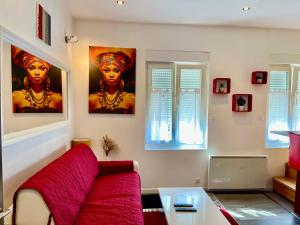 un salon avec un canapé rouge et un tableau dans l'établissement Appartement en duplex proche gare d'Amiens, à Amiens