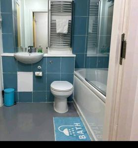 a blue bathroom with a toilet and a sink at Charming Apartment in Liverpool City Centre - Peaceful Sleep! in Liverpool
