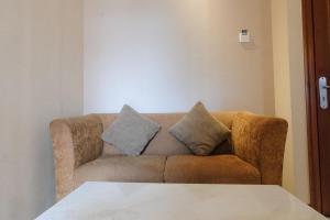 a living room with a couch with two pillows on it at Strategic and Comfy Studio at Grand Setiabudi Apartment By Travelio in Bandung