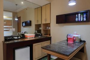a kitchen with a table and a counter top at Strategic and Comfy Studio at Grand Setiabudi Apartment By Travelio in Bandung +6 photos