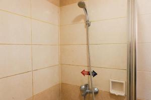 a shower in a bathroom with a glass door at Strategic and Comfy Studio at Grand Setiabudi Apartment By Travelio in Bandung