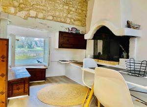 a kitchen with a table and chairs and a fireplace at Le Quai 2, ancien Moulin au Bord de la Charente - Charme et Sérénité à Jarnac in Jarnac