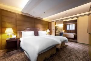 a hotel room with a large bed and a bathroom at The Landis Taipei in Taipei