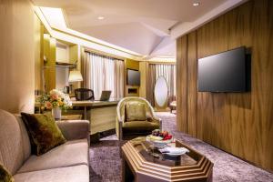 a living room with a couch and a television on a wall at The Landis Taipei in Taipei +37 photos