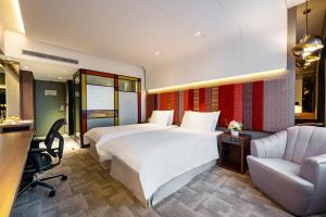 a hotel room with a bed and a desk and a chair at The Landis Taipei in Taipei