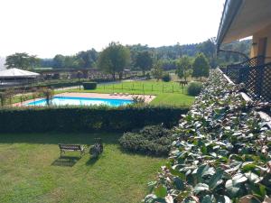 a hedge of plants next to a swimming pool at Agriturismo La Bella Manza in Lurate Caccivio