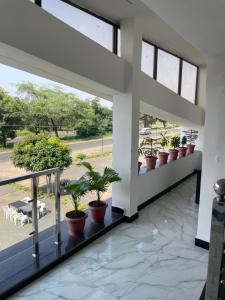 a hallway with potted plants on a balcony at Hotel Moonlight & Restaurant in Sehore