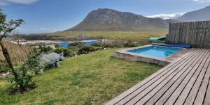 a teddy bear standing next to a swimming pool at Hilltop Heaven, Walk to beach, Pool, Ocean & River views in Pringle Bay