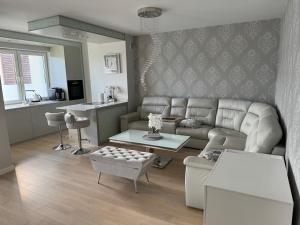 a living room with a couch and a table at AKOYA APARTMENT Cristal Bianco in Koszalin