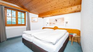 Un dormitorio con una cama y un techo de madera. en Haus Christaldo, en Sankt Anton am Arlberg