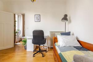 a bedroom with a bed and a desk and a chair at Appartement moderne entier Paris-le Bourget et CDG in Le Bourget