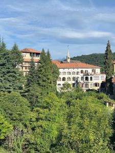 a large white building in the middle of trees at Casa Zuccaro in Valduggia