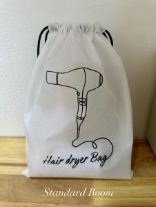 a white shopping bag with a hair dryer on it at Surin Bay Inn in Surin Beach