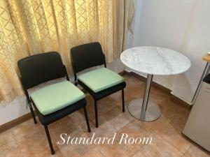 a table and two chairs and a table and a table at Surin Bay Inn in Surin Beach