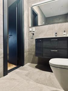 ein Badezimmer mit Toilette, Waschbecken und Spiegel in der Unterkunft KIKI stay and art in Košice