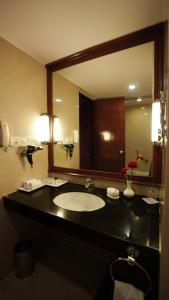 a bathroom with a sink and a large mirror at MGM Mark Whitefield in Bengaluru
