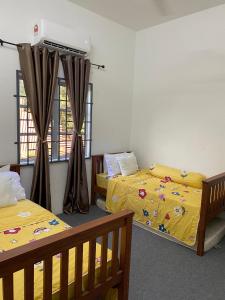 a room with two beds and a window at Kencana L&K Homestay in Air Molek