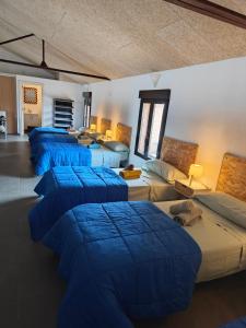 Una habitación con cuatro camas con mantas azules. en loft el taller, en Lumpiaque
