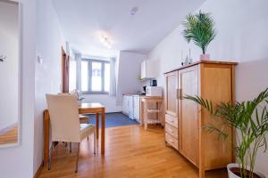a kitchen and dining room with a table and a cabinet at Altstadtloft am Martinstor in Freiburg im Breisgau +5 photos