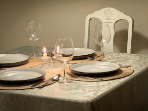 Una mesa con platos y copas de vino encima. en Fredelig leilighet med utsiktsplass til nordlys, en Tromsø 24 fotos más