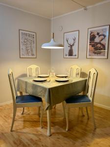 mesa de comedor con sillas y mantel en Fredelig leilighet med utsiktsplass til nordlys, en Tromsø