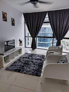 a living room with a couch and a tv and windows at Cozy Haven Queen Deluxe Studio 3 WI-FI Netflix in Petaling Jaya