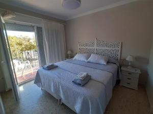 Un dormitorio con una cama con dos toallas encima. en El Parque 4 dormitorios wifi playa centro, en Sanlúcar de Barrameda