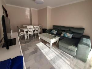 una sala de estar con un sofá y una mesa en El Parque 4 dormitorios wifi playa centro, en Sanlúcar de Barrameda